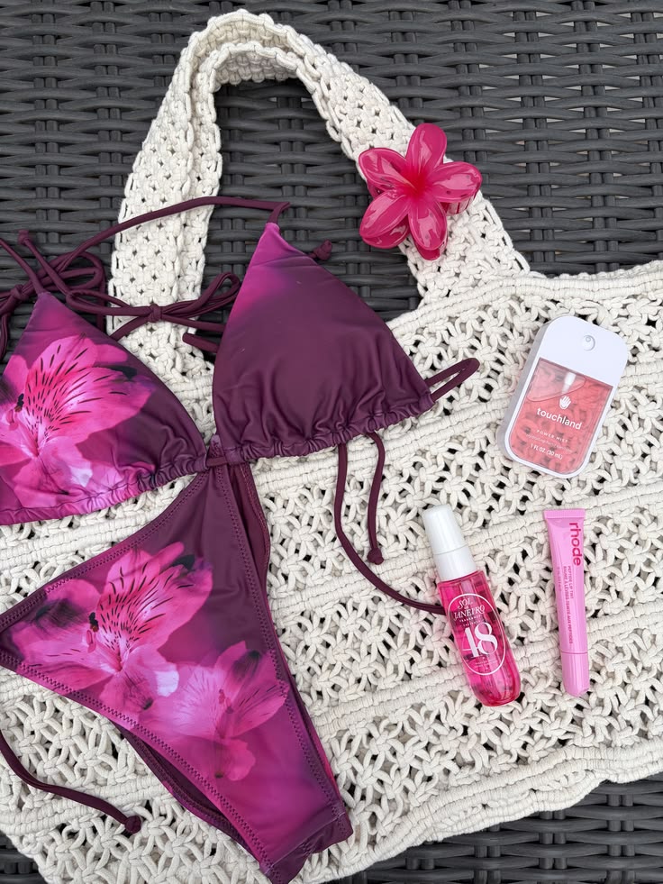 Pink floral beach bikini flat lay with beach bag contents